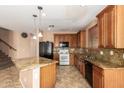 Spacious kitchen featuring wooden cabinets, granite countertops, tile floors and black appliances at 3127 W Apollo Rd, Phoenix, AZ 85041