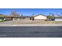 Modest home with beige exterior, brick accents, solar panels, and a well-manicured lawn at 3210 W Belmont Ave, Phoenix, AZ 85051