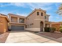 Two-story home featuring a turret entry, a balcony, desert landscaping, and a two-car garage at 3891 E Melrose St, Gilbert, AZ 85297