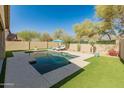 An outdoor pool with lounge chairs, umbrella, and artificial grass at 39526 N White Tail Ln, Anthem, AZ 85086