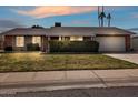 Charming single-story home with a well-maintained lawn and inviting curb appeal at sunset at 4201 W Brown St, Phoenix, AZ 85051