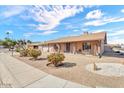 Attractive single-level home with a well-kept front yard, brick exterior, and cozy front porch at 4826 E Navajo Cir, Phoenix, AZ 85044