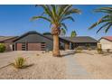 Charming home showcasing desert landscaping, wooden garage door, and concrete stepping stones at 5726 E Woodridge Dr, Scottsdale, AZ 85254