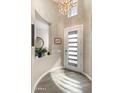 Charming entryway features a modern door, designer chandelier, and a decorative niche with stylish accents at 70 E Kennedia Dr, Queen Creek, AZ 85140