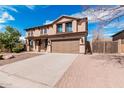 Charming two-story home featuring an attached two-car garage and desert landscaping at 7910 W Spur Dr, Peoria, AZ 85383