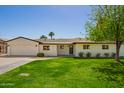 Lovely single-story home with green lawn, brick accents and a two-car garage at 829 E Desert Park Ln, Phoenix, AZ 85020