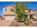 View of a two-story home with desert landscaping and a two-car garage at 9382 W Louise Dr, Peoria, AZ 85383