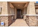 Covered front porch with stone pillars and brick flooring at 9382 W Louise Dr, Peoria, AZ 85383