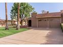 Charming home with a two-car garage, beautiful landscaping, and healthy green lawn at 9837 E Michigan Ave, Sun Lakes, AZ 85248