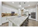 Spacious kitchen with white cabinets, stainless steel appliances, and large granite island with barstool seating at 10049 E Topaz Ave, Mesa, AZ 85212
