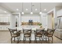 Open kitchen with large island, barstool seating, pendant lights, white cabinets, and stainless steel appliances at 10049 E Topaz Ave, Mesa, AZ 85212