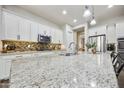Bright kitchen features granite counters, stainless appliances, backsplash and a large island with seating at 10049 E Topaz Ave, Mesa, AZ 85212