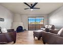 Comfortable living room with a corner fireplace, wood-look flooring, and a view of the outdoor area through a large window at 10410 N Cave Creek Rd # 2232, Phoenix, AZ 85020