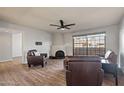 Cozy living room features wood floors, a corner fireplace, and great natural light from large, grid-style windows at 10410 N Cave Creek Rd # 2232, Phoenix, AZ 85020