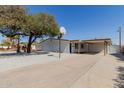Inviting front exterior of home with a covered carport, a basketball hoop, and attractive landscaping at 12207 N Escobar Way, Phoenix, AZ 85022