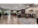 Open-concept living room featuring hardwood floors, modern decor, and seamless flow to the kitchen at 12924 W Caraveo Pl, Peoria, AZ 85383