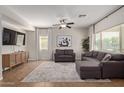 Bright living room featuring tile floors, a ceiling fan, and a comfortable gray sectional sofa with natural light at 1329 W Crape Rd, Queen Creek, AZ 85140