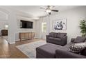 Comfortable living room with neutral paint, a ceiling fan, tile floors, and a plush gray sectional sofa at 1329 W Crape Rd, Queen Creek, AZ 85140