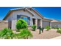 Inviting single-story home with desert landscaping, complemented by lush green bushes and trees enhancing curb appeal at 15262 W Garfield St, Goodyear, AZ 85338
