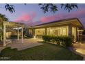 Backyard patio featuring a pergola with a shade sail and manicured lawn, perfect for outdoor living at 18635 W Miami St, Goodyear, AZ 85338