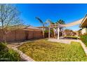 Spacious backyard features a grassy lawn, patio with pergola, and privacy wall, ideal for outdoor relaxation at 18635 W Miami St, Goodyear, AZ 85338