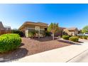 Side view of an earth-toned home with manicured landscaping and gravel, with an American flag on a clear day at 18635 W Miami St, Goodyear, AZ 85338