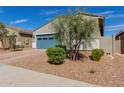 Single-story home with a blue garage door, brick driveway, and low maintenance landscaping at 19924 W Rancho Dr, Litchfield Park, AZ 85340