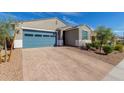 Single-story home with a blue garage door, brick driveway, and low maintenance desert landscaping at 19924 W Rancho Dr, Litchfield Park, AZ 85340