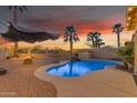 Backyard pool with palm trees, pavers, and a beautiful sunset view at 22491 W Woodlands Ave, Buckeye, AZ 85326