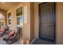 Welcoming front porch with comfortable seating, stylish lanterns, and a secure screen door entry at 3103 S Dakota Pl, Chandler, AZ 85248