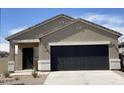 Close up of a charming single-story home featuring a two-car garage and desert landscaping at 36638 W Santa Clara Ave, Maricopa, AZ 85138