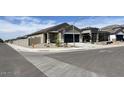 Street view of a charming single-story home featuring a two-car garage and desert landscaping at 36638 W Santa Clara Ave, Maricopa, AZ 85138