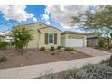 Inviting single-story home featuring a well-maintained lawn and a two-car garage at 5189 N 206Th Dr, Buckeye, AZ 85396