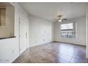 Bright living room with tile floors, ceiling fan, and large window providing natural light at 5303 N 7Th St # 101, Phoenix, AZ 85014