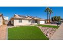 Inviting single-Gathering home with an expansive green lawn, desert-style landscaping, and a two-car garage at 562 W Keats Ave, Mesa, AZ 85210