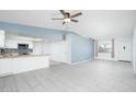 Bright living room featuring gray tile flooring, modern lighting, and an open floor plan to the kitchen at 562 W Keats Ave, Mesa, AZ 85210