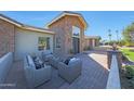 Inviting outdoor patio with comfortable seating, brickwork, and a charming view of the home's front entrance at 6615 E Shea Blvd, Scottsdale, AZ 85254