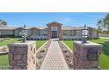 Beautiful single-story home with a brick walkway leading to the entrance, flanked by well-manicured lawns at 6615 E Shea Blvd, Scottsdale, AZ 85254