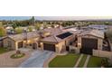 Beautiful home exterior featuring a circular driveway, three-car garage, and well-maintained landscaping at 7157 E Ivyglen Cir, Mesa, AZ 85207