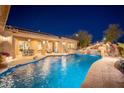 Luxurious backyard boasts a beautiful pool with rock features and patio, creating a perfect space for outdoor living and entertaining at 7157 E Ivyglen Cir, Mesa, AZ 85207