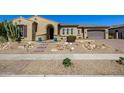 Charming home featuring a desert landscape, arched entryway, and colorful potted plants at 7576 W Quail Ave, Glendale, AZ 85308