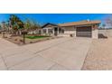 Well-maintained home with tidy front yard, xeriscaping, and a spacious driveway leading to a single car garage at 836 W Watson Dr, Tempe, AZ 85283