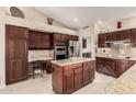 Spacious kitchen with cherry wood cabinets, granite countertops, stainless steel appliances, and an island at 10031 E Nacoma Ct, Sun Lakes, AZ 85248