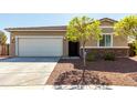 Charming single-story home showcasing a two-car garage, desert landscaping, and stone accents at 101 W Seven Seas Dr, Casa Grande, AZ 85122