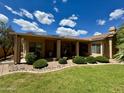 Manicured backyard featuring lush lawn, tasteful landscaping, and a covered patio at 1339 N Tucana Ln, Gilbert, AZ 85234