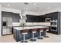 Modern kitchen featuring stainless steel appliances, a large island with seating, and sleek black cabinetry at 14194 W Sand Hills Rd, Surprise, AZ 85387