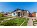 Charming single story home with white exterior, blue shutters, green lawn and brick pathway at 1534 E Pierce St, Phoenix, AZ 85006