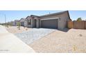 Attractive single-story home featuring a paver driveway, xeriscaped yard, and a two-car garage at 1661 N St Francis Pl, Casa Grande, AZ 85122