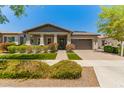 Charming single-story home boasts a well-manicured lawn, mature landscaping, and a covered porch at 20584 W Hillcrest Blvd, Buckeye, AZ 85396