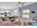 Open-concept living room with modern furnishings, a ceiling fan, and light wood floors at 21640 N 48Th St, Phoenix, AZ 85054